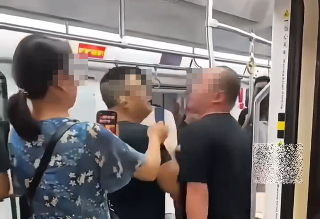 大陆有民眾拍到，两名男乘客搭地铁时爆发口角纠纷，岂料，双方互喷口水的过程中，还一度要亲到嘴。（图／翻摄自微博）