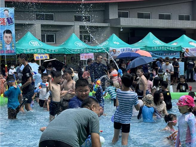 炎夏来临，民眾党台中市议员江和树7日在大里十九甲健康公园举办「大里人泼水节」迎接酷暑，现场设置大水池、多座充气城堡与美食摊商，民眾带上水枪、换上短T短裤带着孩子到场戏水，个个玩得不亦乐乎。（潘虹恩摄）