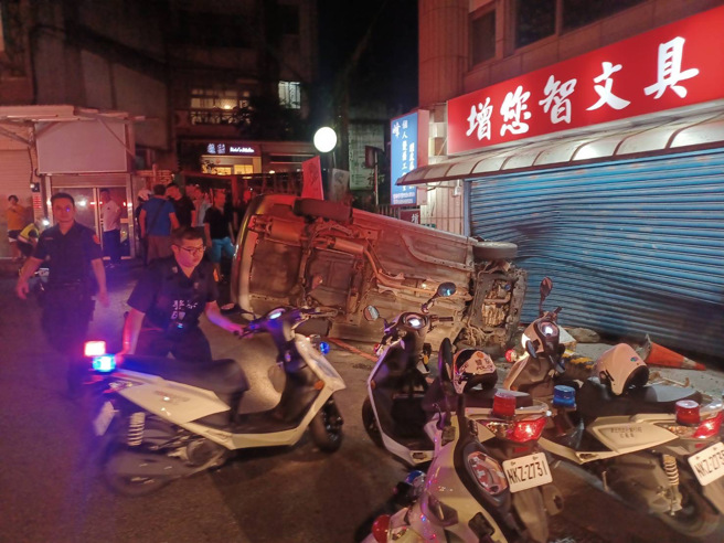 轎車撞擊旁邊文具店鐵捲門後側翻，駕駛由消防隊救出送醫。（翻攝畫面）