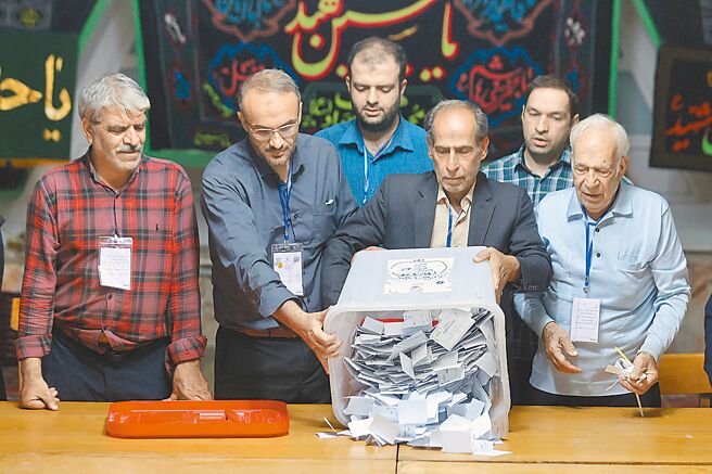 伊朗内政部6日宣布，前卫生部长裴泽斯基安在总统大选中获胜。图为德黑兰某处投票站选务人员清空投票箱。（路透）