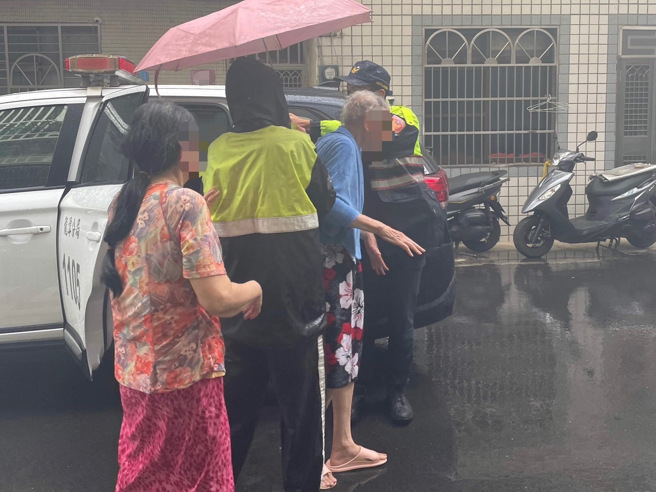 阿公午後雷雨呆坐路邊淋雨，龍潭暖警撐傘助平安返家。（翻攝畫面）