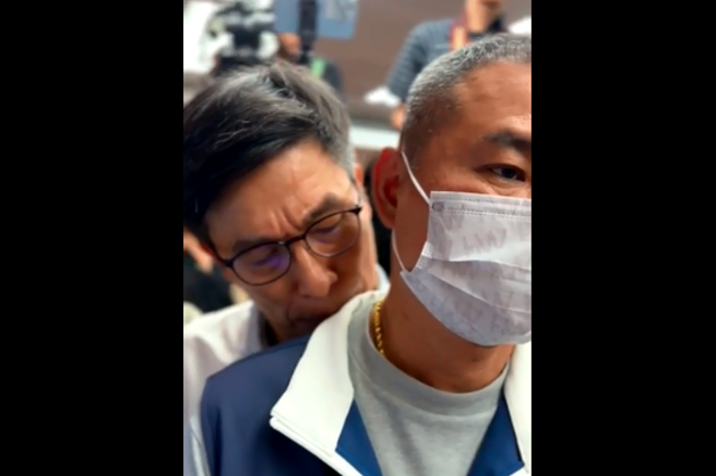 民进党立委锺佳滨（左）被拍到偷亲国民党立委丁学忠（右）肩膀的画面，不只旁人直呼「很变态欸」，丁也无奈表示「好了啦」。（图 / 取自中天新闻）