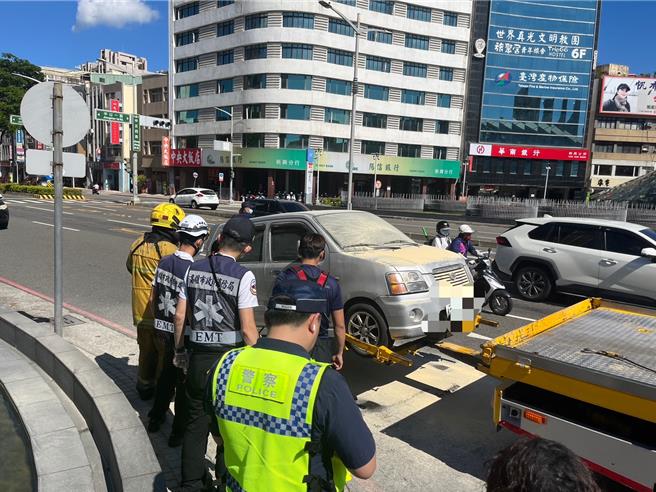 高雄一輛小房車引擎疑似故障，駕駛下車後開始冒煙，一旁警方見狀立即持滅火器前往撲滅。（警方提供／任義宇高雄傳真）