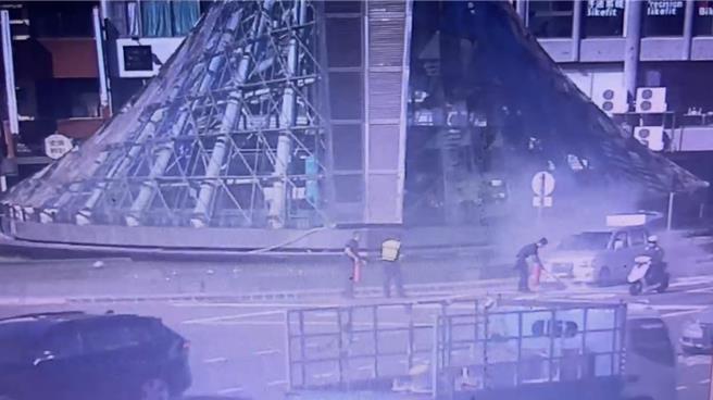 高雄一輛小房車引擎疑似故障，駕駛下車後開始冒煙，一旁警方見狀立即持滅火器前往撲滅。（警方提供／任義宇高雄傳真）