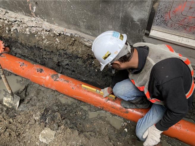 後巷污水管埋設時，施工人員進行管線坡度檢測。（新北市水利局提供）