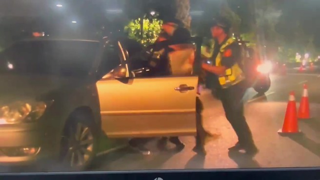 警方命令林男下车配合盘查，林男却企图将随身携带的烟盒吞入口内，员警当机立断将其压制。（翻摄画面）