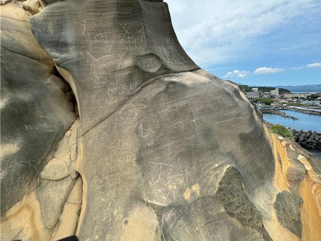 新北市万里区「维纳斯海岸骆驼峰」6日被民眾爬上刻字，造成石头上新增多处刻痕，民眾还称「应该带电钻来刻字」，交通部观光署北海岸暨观音山风景区管理处副处长施宗泓指出，民眾举动已违反《发展观光条例》，若造成无法復原，可以罚到500万元。（柯毓庭摄）