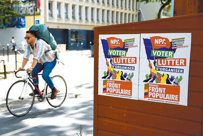 法国7日举办国民议会决选，极右翼迈向最大党。图为一名男子骑车靠近左翼政党「反资本主义党」的竞选海报。（路透）