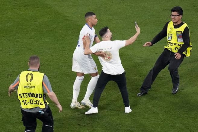 鬧場球迷抓著姆巴佩自拍。（美聯社）