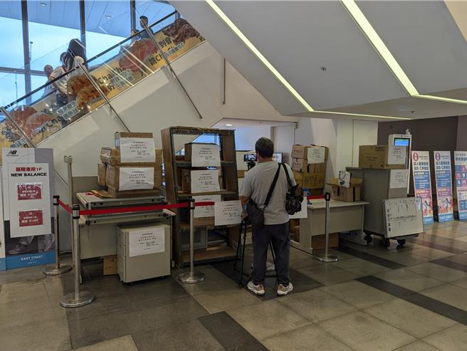 基隆地检署发还给主富公司的物品，暂时堆放在东岸商场的手扶梯下，主富公司律师还贴上「强盗赃物暂置区」等字样。（张志康摄）