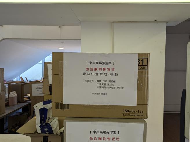 基隆地检署发还给主富公司的物品，暂时堆放在东岸商场的手扶梯下，主富公司律师还贴上「强盗赃物暂置区」等字样。（张志康摄）