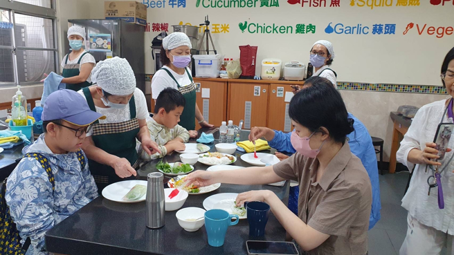 食育士在旁協助親子製作春捲。(照片/新北市政府教育局提供)