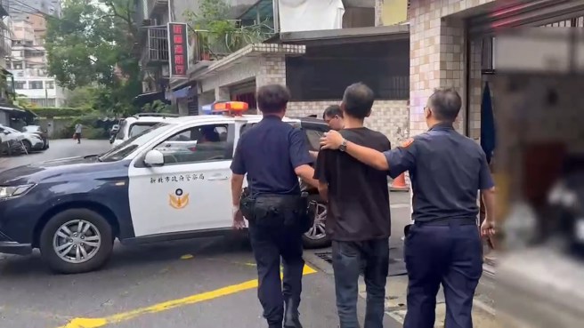 汐止福德一路警察抓嫌犯，嫌犯爬窗逃逸卡在遮雨棚，由消防队救下后顺利逮捕。（翻摄画面）