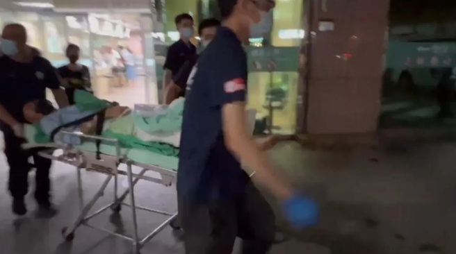 「威震」董座吳明達與司機轉院榮總，現場大批警力在醫院外警戒。畫面為囊姓司機躺在擔架上。（圖／翻攝自中天新聞）