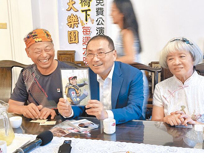 荣获今年度模范父亲的朱明义（左）与新北市长侯友宜（中）閒话家常，朱爸爸开心地向侯友宜分享精采丰富的生命经歷。（高钧麟摄）