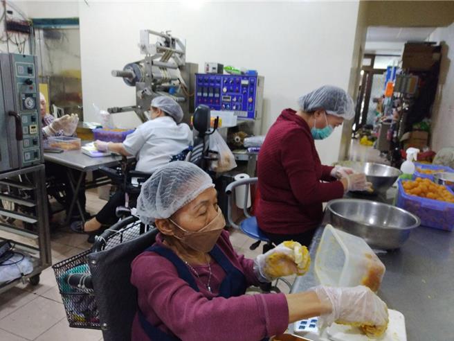 身障朋友坐著輪椅認真用心製作鳳梨酥，需要您大力支持。（社會局提供／林雅惠高雄傳真）