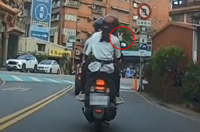 有騎士載著女乘客，不料，當他喬完後照鏡，後座女乘客開心比YA，竟遭到檢舉2項交通違規。（圖／翻攝自WoWtchout - 地圖型行車影像分享平台）
