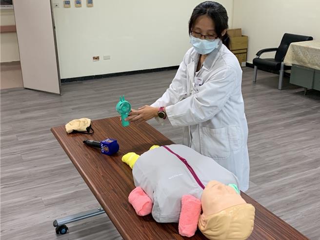 台中医院急诊室自6个月起每天平均都有2至3名患者因为热伤害就医，急诊室主任陈莉玮12日示范热伤害处置方式，先将患者移至阴凉处，并在颈部、腋下等位子放上冰块协助降温。（潘虹恩摄）