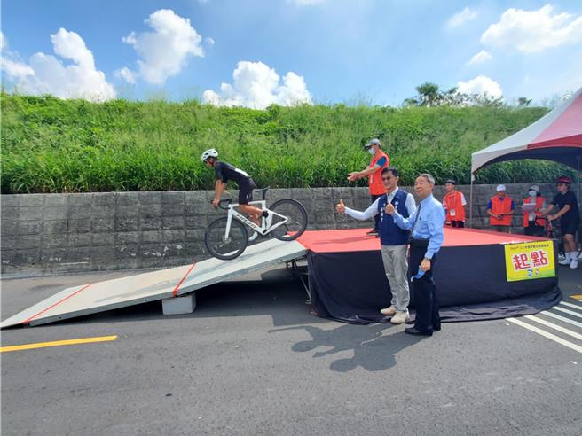 云林县首次自由车县赛13日举行个人计时赛，西螺七崁武术文教基金会董事长丁振源（右）、前董事长李明哲（左）为选手打气。（周丽兰摄）