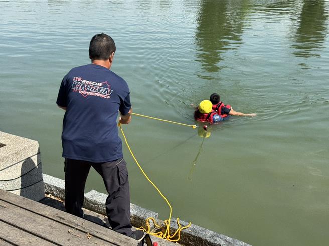 金门县消防局第一大队办理水域救援组合演练，由救援人员穿着激流救生衣，以攻击式泳姿接近第2名溺者将其救回。（图／金门县消防局）