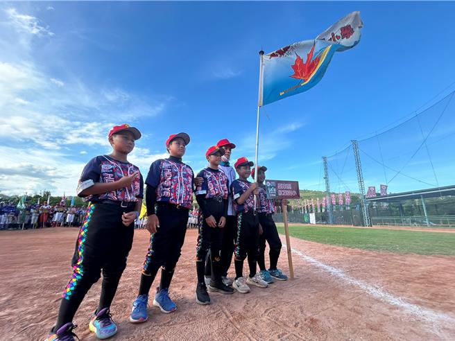 红叶少棒队初代球员胡明澄（右二）将红叶国小队旗授予现任队员。（萧嘉蕙摄）