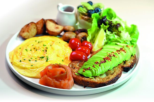 〈经典大早餐〉内有鲑鱼、蔬菜沙拉、烤马铃薯、蘑菇、小番茄、莓果优格，以及铺在酸种麵包上的酪梨。图／姚舜