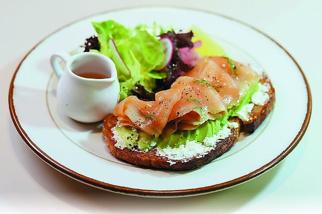 〈清新熏鲑鱼酪梨酸种麵包〉有熏鲑鱼片、生菜，以及涂着酪梨酱的手工酸种麵包。图／姚舜