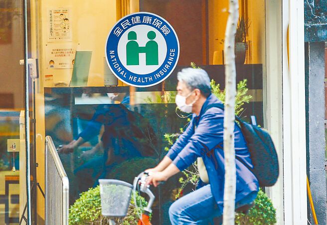 健保署12日共同擬定會議通過「社區醫院全人全社區照護計畫」，署長石崇良宣布，將砸3.5億元，補助社區醫院將慢性病患收案。圖為單車騎士路過一間健保診所。（本報資料照片）