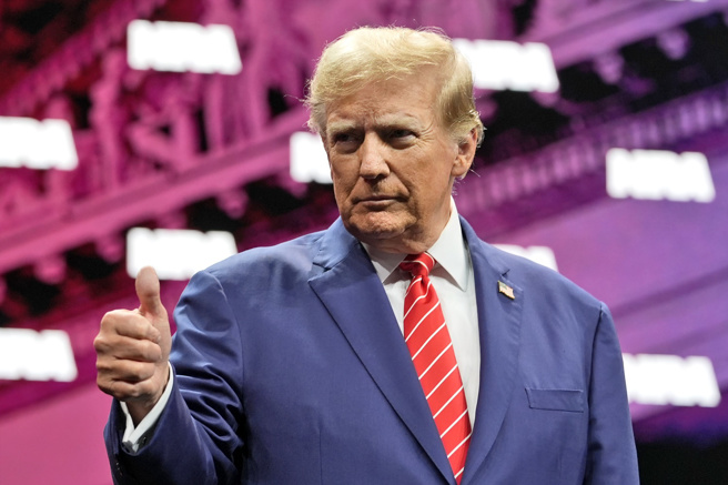 川普造势遭枪击，他今（2024）年出席全国步枪协会（NRA）会议时，还自称是「拥枪者在白宫的好朋友」。图为他5月出席全国步枪协会年会时比讚。（资料照／美联社）