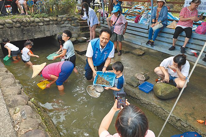 頭份市下興社區尖山圳洗衫坑，被當地居民打造成生態保育園區，13日數百老少同聚，重溫摸蛤仔兼洗褲的樂趣。（謝明俊攝）