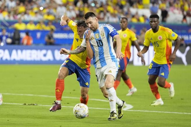 哥伦比亚后卫阿里亚斯(左)与阿根廷梅西碰撞。（美联社）