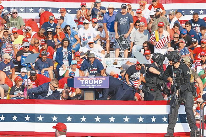 美國前總統川普在競選造勢場合遭到槍擊，槍聲傳出後，特勤人員趕忙護住川普。（路透）