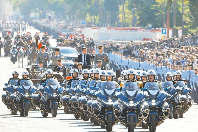 法国国会选举结束，法总统马克宏16日将接受总理艾塔尔请辞，但新总理人选仍未达成共识。图为14日法国国庆，马克宏在车上挥手致意。（路透）