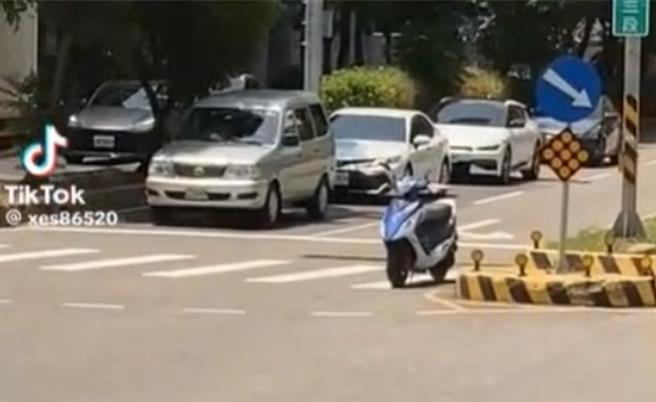 有机车骑士在红灯时将机车停斑马线，自己躲到树下纳凉。(取自TikTok／吕筱蝉桃园传真)