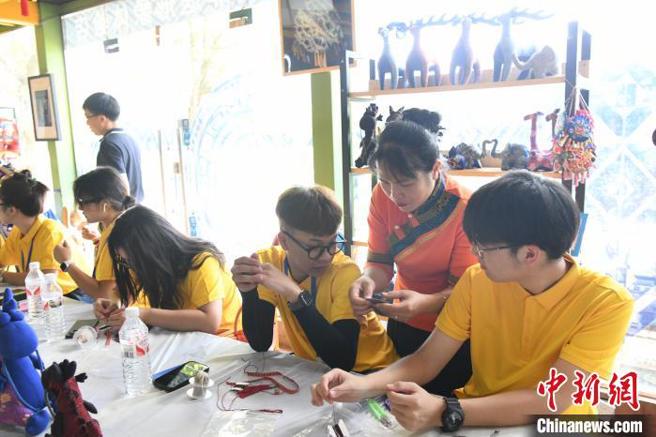 圖為台青郭彧佐(右三)在跟老師一起學習壯族刺繡。（中新網）