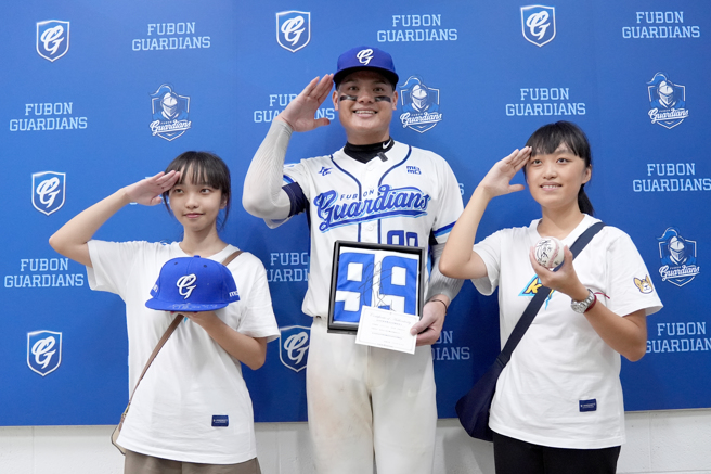 张育成（中）与捡到他中职首轰球的球迷合照。（富邦悍将提供）