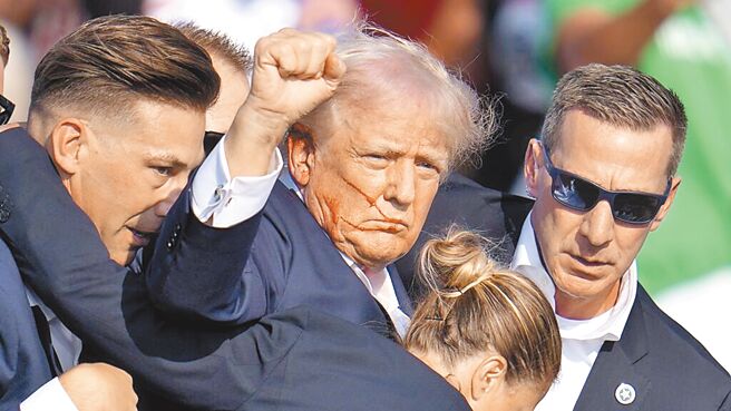 美国前总统、共和党总统参选人川普13日在造势活动上遭枪击，还不忘朝向支持者挥拳示意（图／美联社）