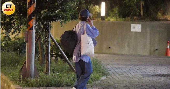 吴婉君戴着帽子、口罩，身穿大号衬衫宽裤，脚踩白色凉鞋，包得很密实，虽然才没等多久，但她显得有点急，东张西望还一直讲电话。（图／本刊摄影组）