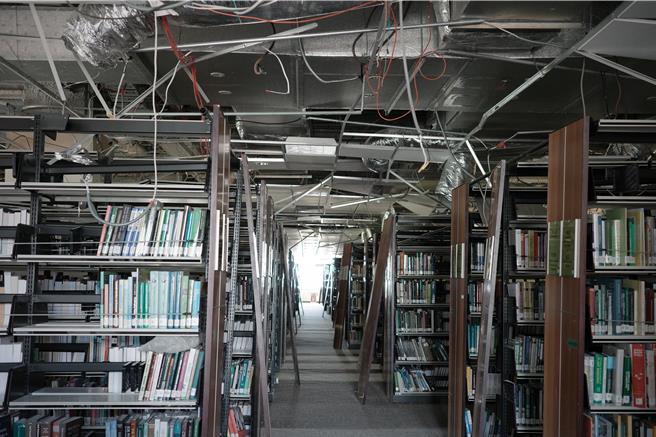 国立东华大学图书馆因0403花莲大地震受损严重，4到6楼的轻钢架天花板掉落造成管线外露，书架也因剧烈摇晃出现严重歪斜的状况。（罗亦晽摄）