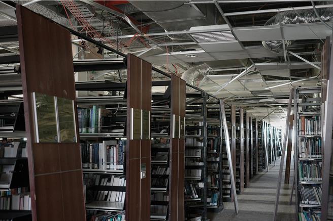 国立东华大学图书馆因0403花莲大地震受损严重，4到6楼的轻钢架天花板掉落造成管线外露，书架也因剧烈摇晃出现严重歪斜的状况。（罗亦晽摄）