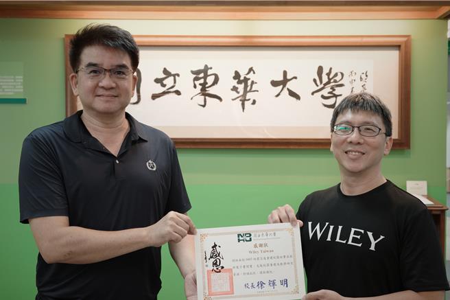 国际期刊出版社「Wiley」捐赠总价值约1亿元的2.4万多册线上电子书，免费提供东华大学师生使用，校方图书资讯处长陈伟铭（左）今天致赠感谢状给Wiley业务经理程世仁（右），感谢出版社的爱心。（罗亦晽摄）