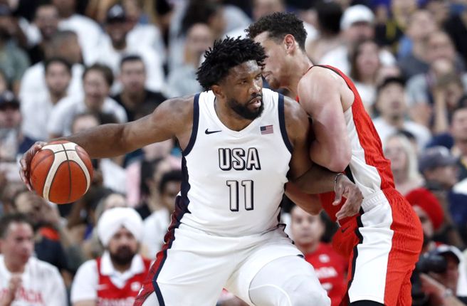 美国队中锋恩比德持球对抗加拿大球员。（美联社资料照）