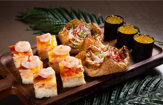 「海味狂飨 夏日海鲜季」点心房特制甜咸点，以分子料理概念打造，外型如鲑鱼卵军舰寿司的「百香果巧克力蛋糕」(右)，粒粒分明的鲑鱼卵以百香果酱制成，既有趣又美味。(台北万豪酒店提供)
