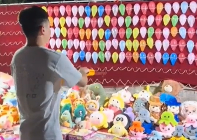 大陆山东省有男子去玩射气球摊位，他为了要多帮助摆摊的老奶奶故意射不中，但竟然被老奶奶反亏「别可怜我」。（图／翻摄自微博）