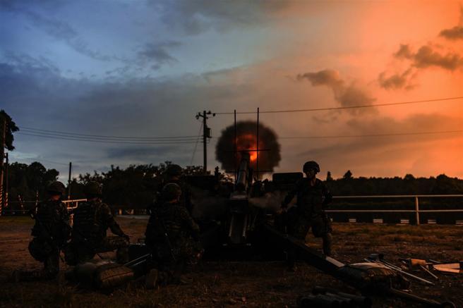 陸軍裝甲584旅砲兵營昨日實施基地營教練夜間實彈射擊，在完成標竿設置等多項前置作業後，接續依作戰階段與狀況誘導，在昏暗天色中完成105榴砲射擊程序，展現砲兵部隊全天候火力支援能量。（記者陳彥陵攝）
