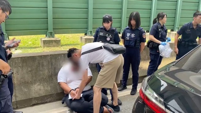 嫌犯被上铐后坐在地上，随后被带回侦讯。（翻摄画面）