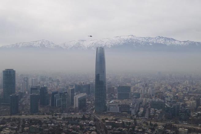 一架直升机 7 月 18 日在智利圣地亚哥上空盘旋的画面。（图／美联社）