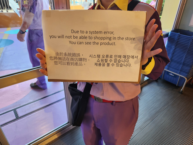 微软系统崩溃影响日本大阪环球影城，工作人员协助游客解决购买问题。（读者提供）