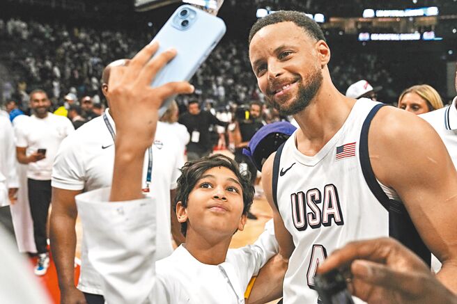美國男籃射手柯瑞（右）在熱身賽擊敗塞爾維亞後配合小球迷自拍。（美聯社）