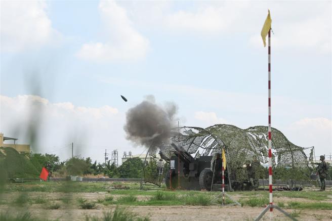 陆军装甲第584旅炮兵营基地营教练昨日实施105榴炮实弹射击，官兵在烈日高温下，完成弹药装填等联合操作，然后实施射击；炮弹伴随巨大声响由炮管射出，命中目标区，展现扎实的基训成效。（记者黄迪明摄）